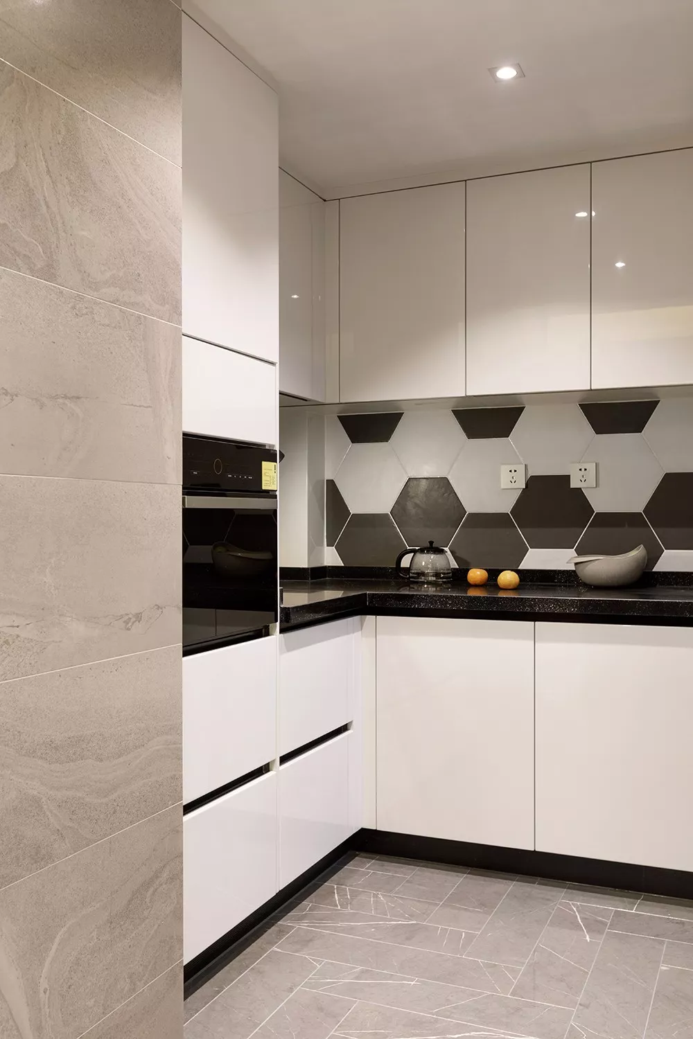 u字形的厨房,在灰色地砖与墙面基础,搭配白色橱柜,黑色台面,显得
