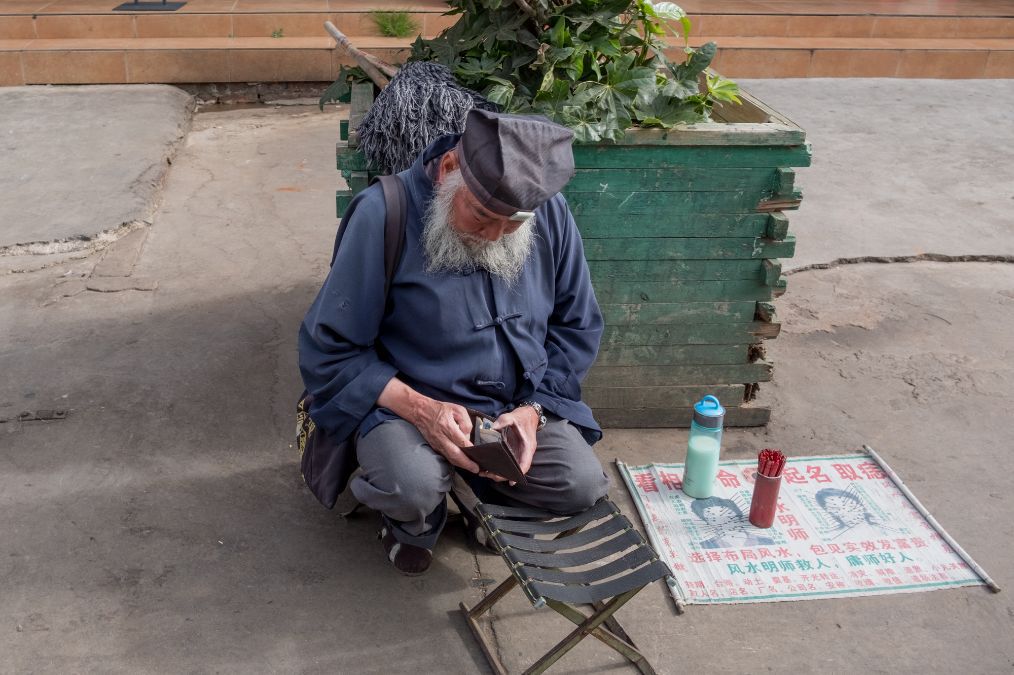 街拍昆明城中村年轻母亲背着小孩讨生活算命摊和擦鞋摊一样多