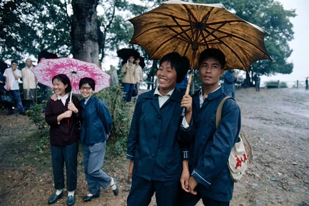 杭州西湖边公园游玩的游客,天空下着小雨.