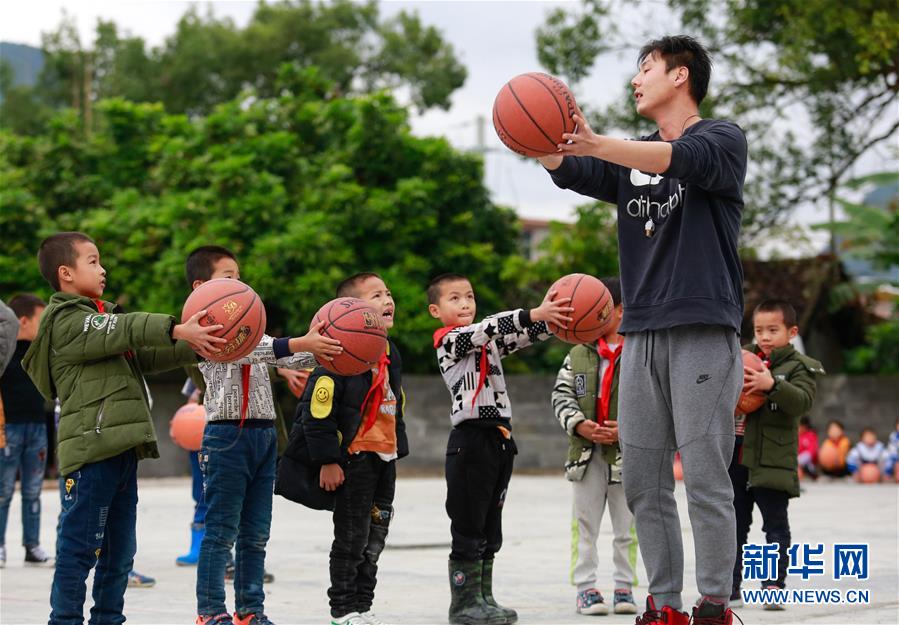 11月21日,在广西柳城县冲脉镇大要村小学,一名篮球教练指导孩子们打