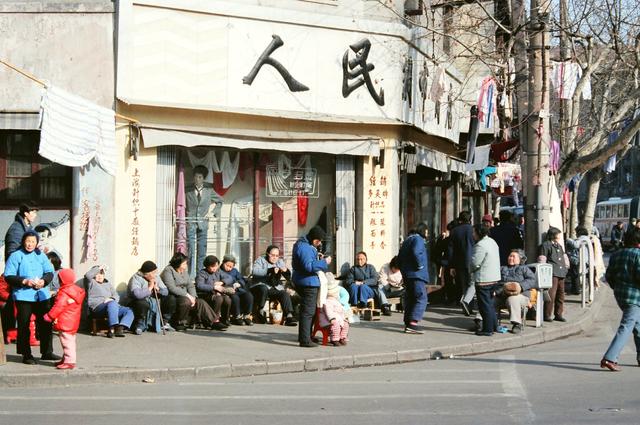 当年许多老百姓还在穿棉袄,照片中的上海人已经穿上了羽绒服.