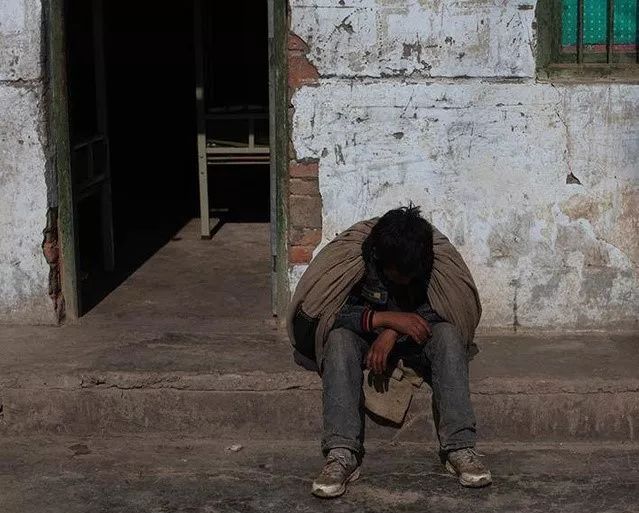 这位孤儿无助地坐在地上痛哭,他的父亲几天前因为吸毒过量,衰竭而死.