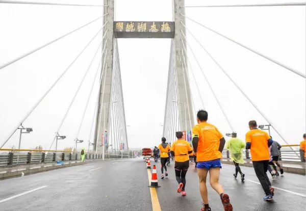 跑友在固城湖大桥奔跑"曼跑慢城,闲静高淳",今年高马继续沿用往届的