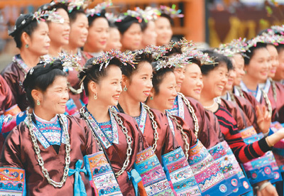 在广西融水苗族自治县洞头镇洞头村,身穿侗族服饰的侗族妇女在寨门口