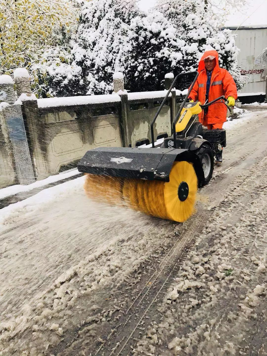 △扫雪车清理主要路面积雪,环卫工人给路面撒盐化雪.