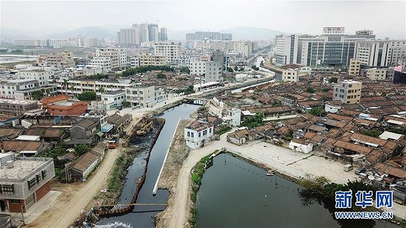 工作人员在广东汕头市谷饶镇练江支流进行清淤工作(12月5日摄).