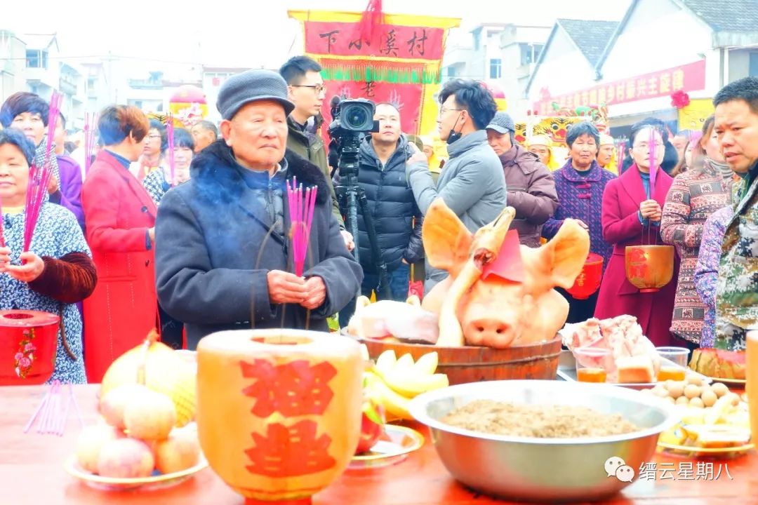 供桌上摆放着猪头,条肉,豆腐,糕点,以及各种水果等祭品.