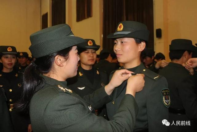 连长,指导员为新兵戴军衔.大队副政委为新同志授衔.女兵们军容严整.