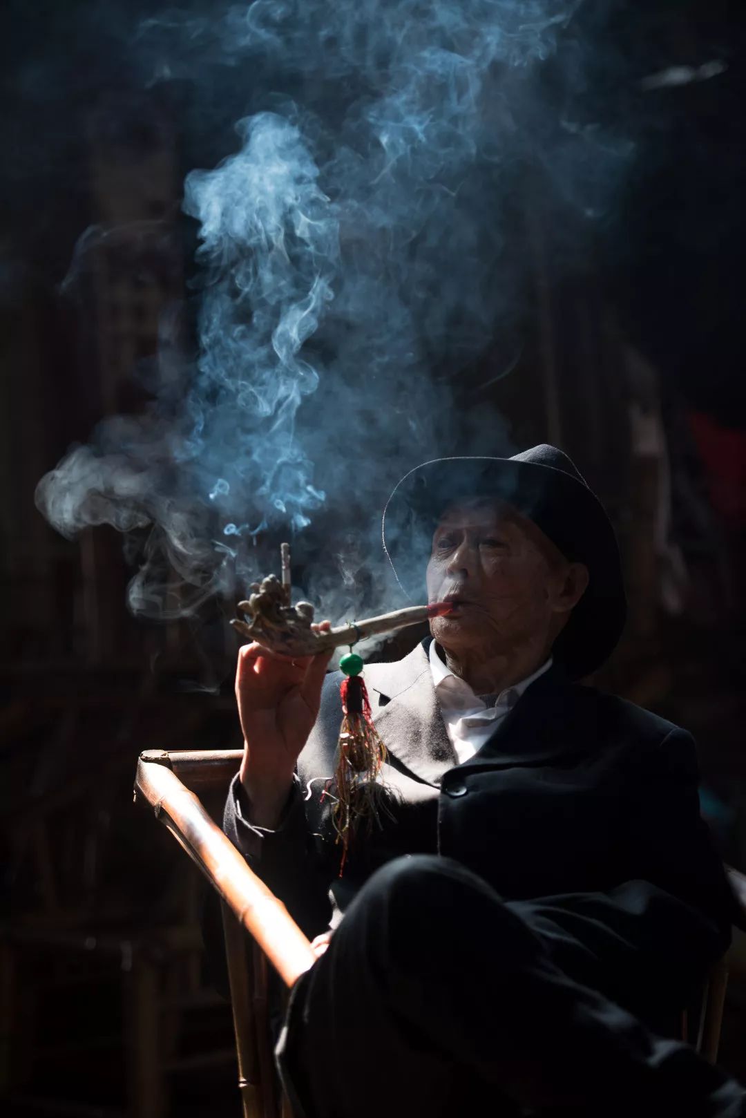 一堆老大爷坐着喝茶聊天下棋,偶然拍到了大爷抽烟时的照片