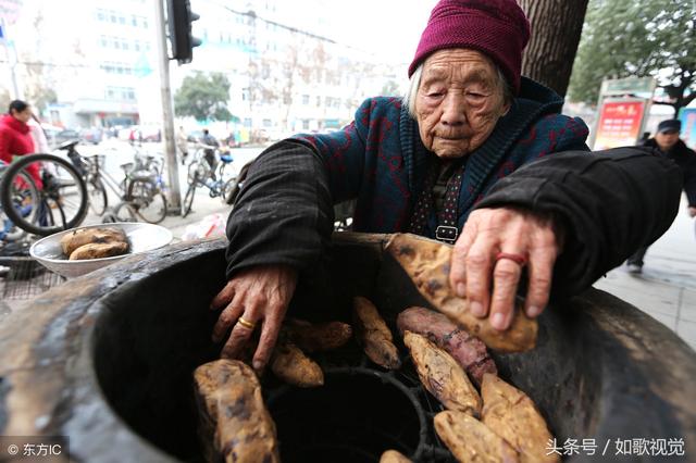 1 12 湖北省襄阳市,一条车水马龙,熙来攘往的道路边,有一位烤红薯卖