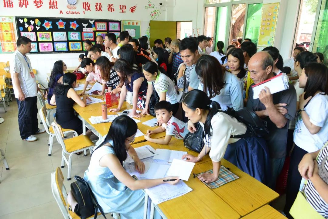 5月5日,拥挤的家长人群在市实验小学咨询小学入学报名事项.