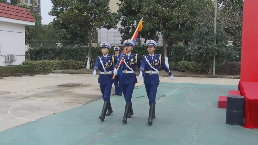 全体人员高唱中华人民共和国国歌,三名仪仗队队员护卫"中国消防救援队