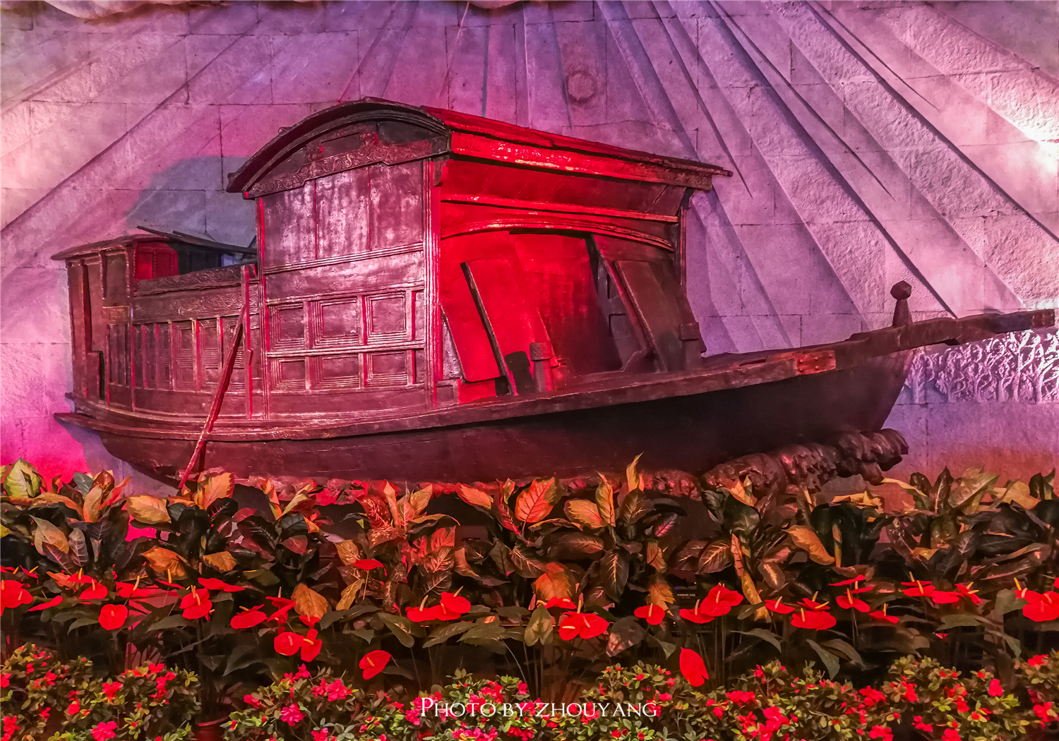 鲜花簇拥着红船,而红船两侧的浮雕则再现中国近代历史上的重大事件