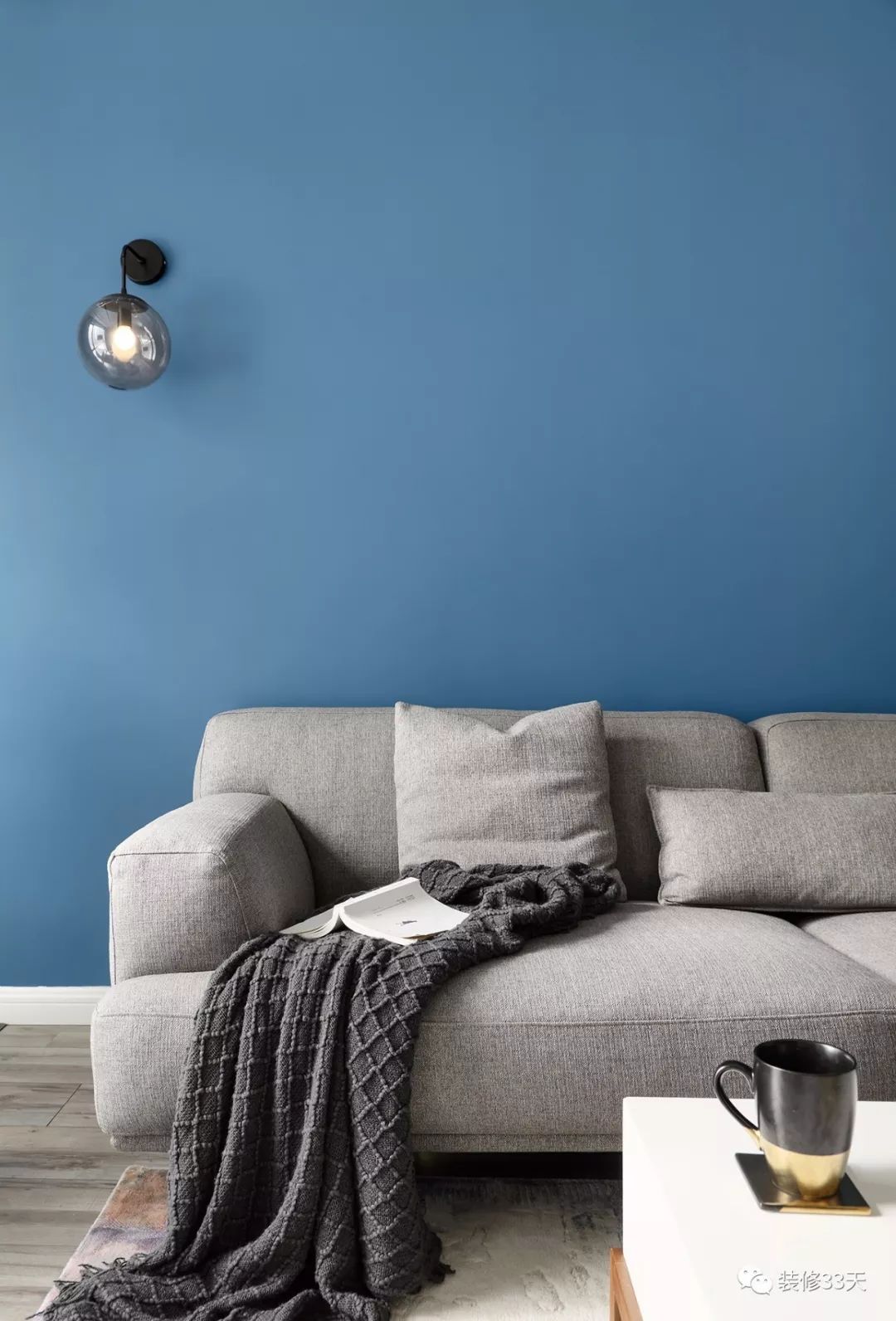 高饱和度的蓝色背景墙搭配灰色沙发,沉稳与跳跃的色彩相互衬托