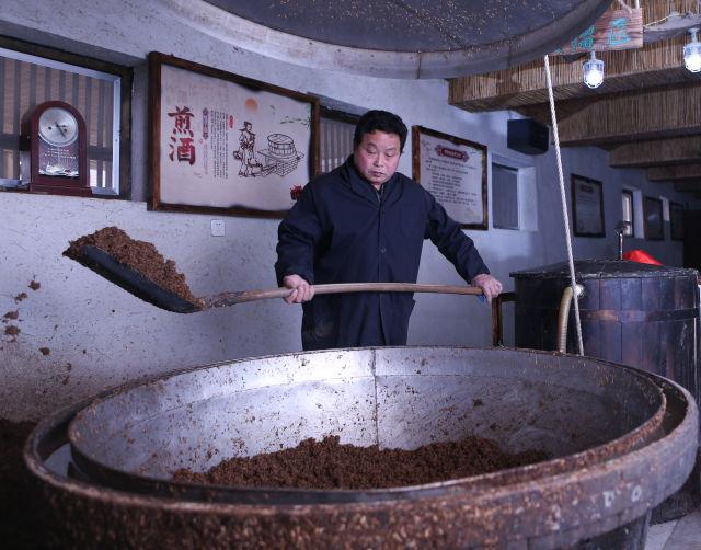 1月10日,来自茅台镇的酿酒师傅冯俊森将酒胚放入酒甑.