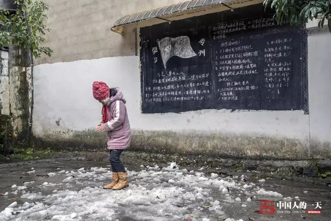 通红的孩子正在露天打乒乓球,一旁三年级的女生李明妍则一边跺着双脚