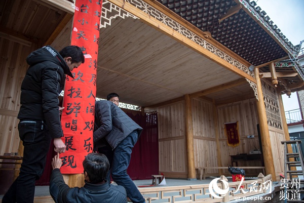 黔东南苗族侗族州从江县西山镇拱村,侗族村民在给新戏台贴对联