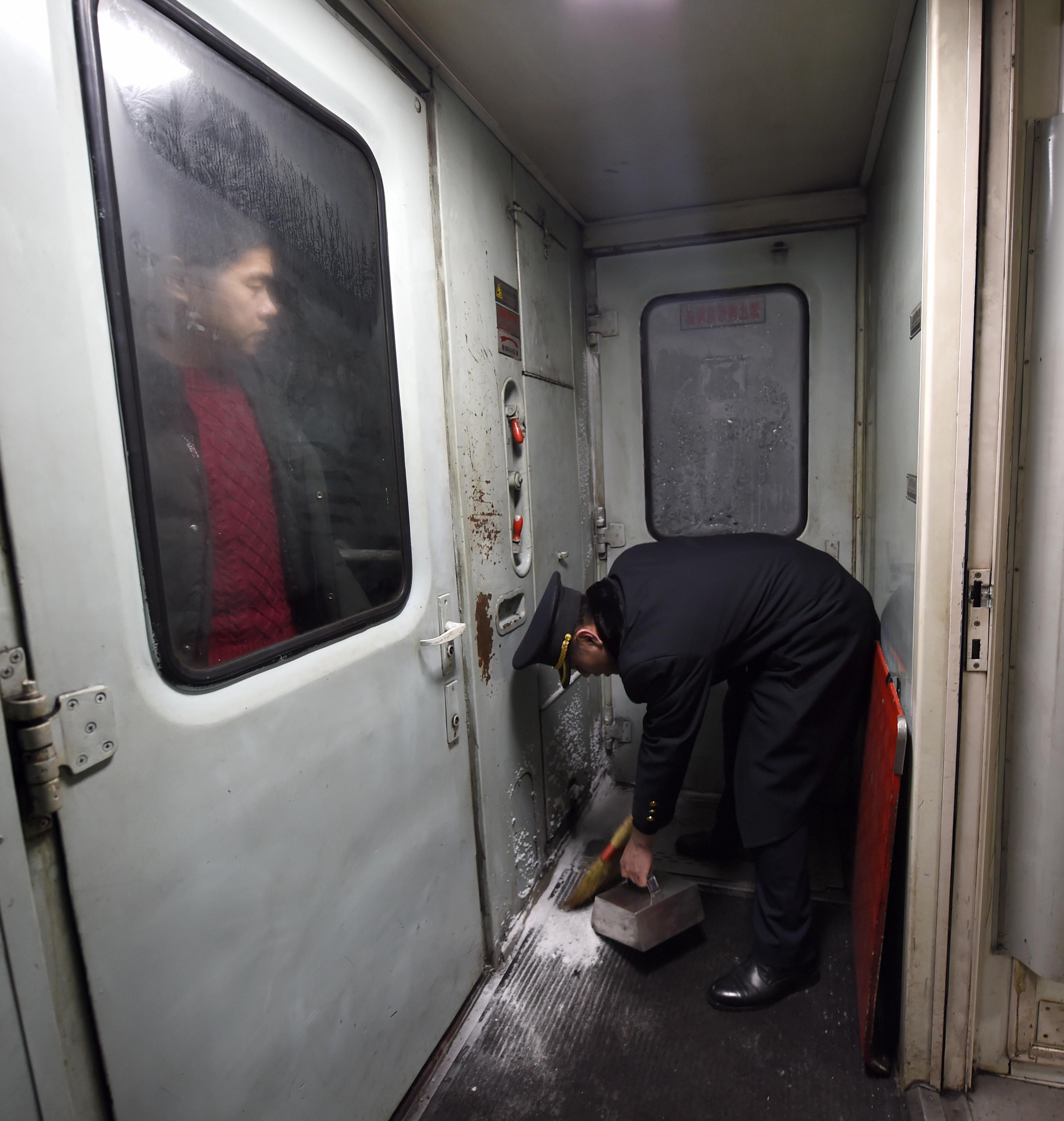1月23日凌晨,在齐齐哈尔开往古莲的6245次列车上,乘务员在车厢连接处