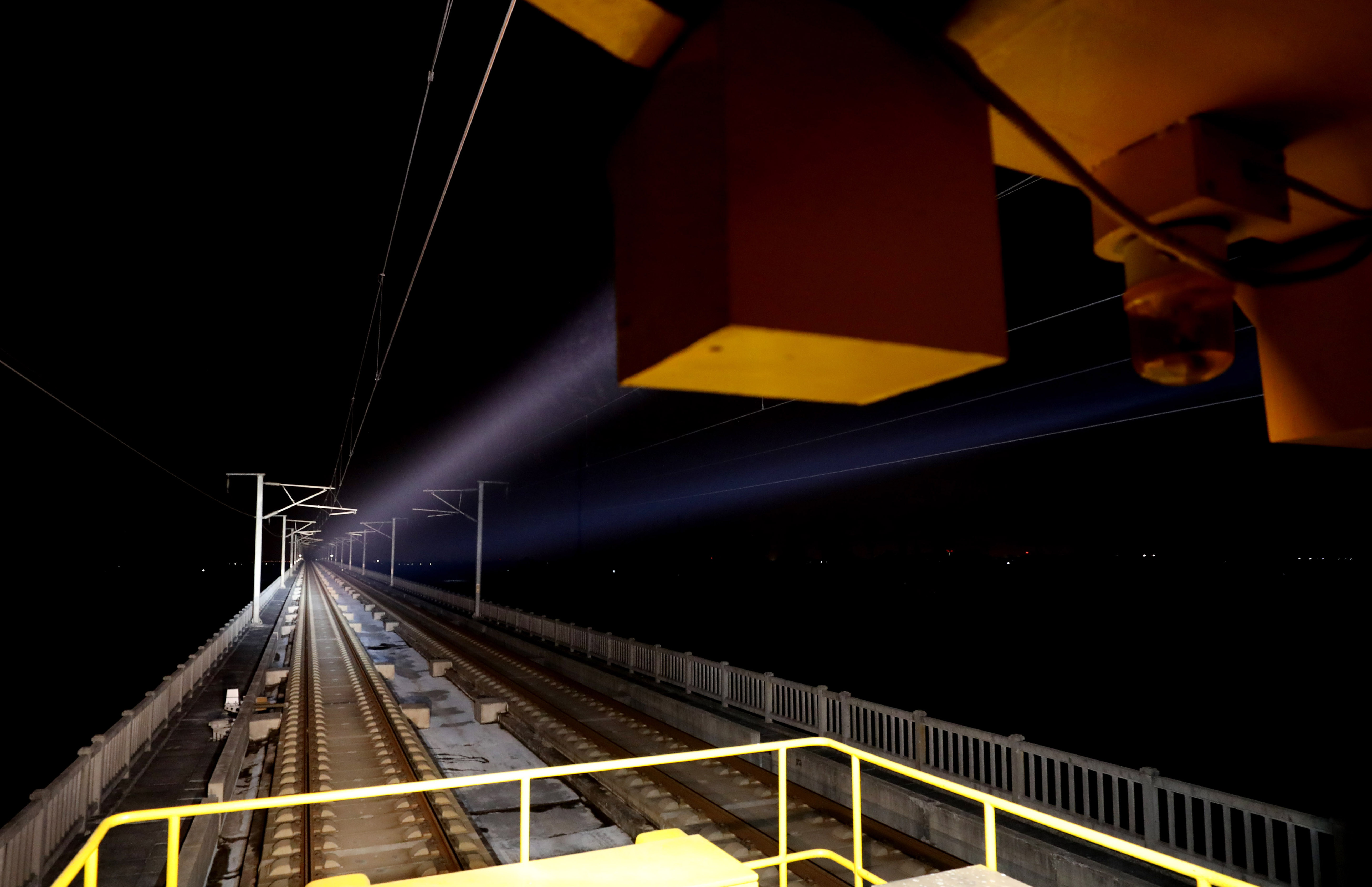 1月30日,巡检车照明灯将前方一段铁路线照亮.