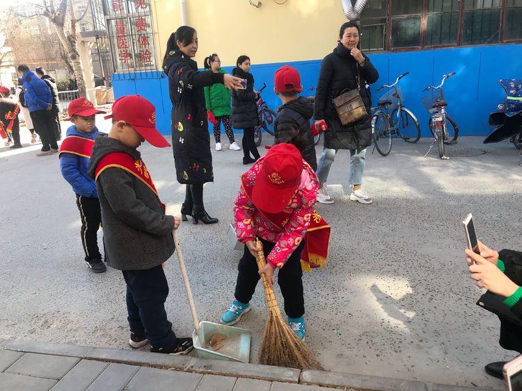 光明南小学一年级六班的小朋友利用寒假时间进社区争做小小志愿者