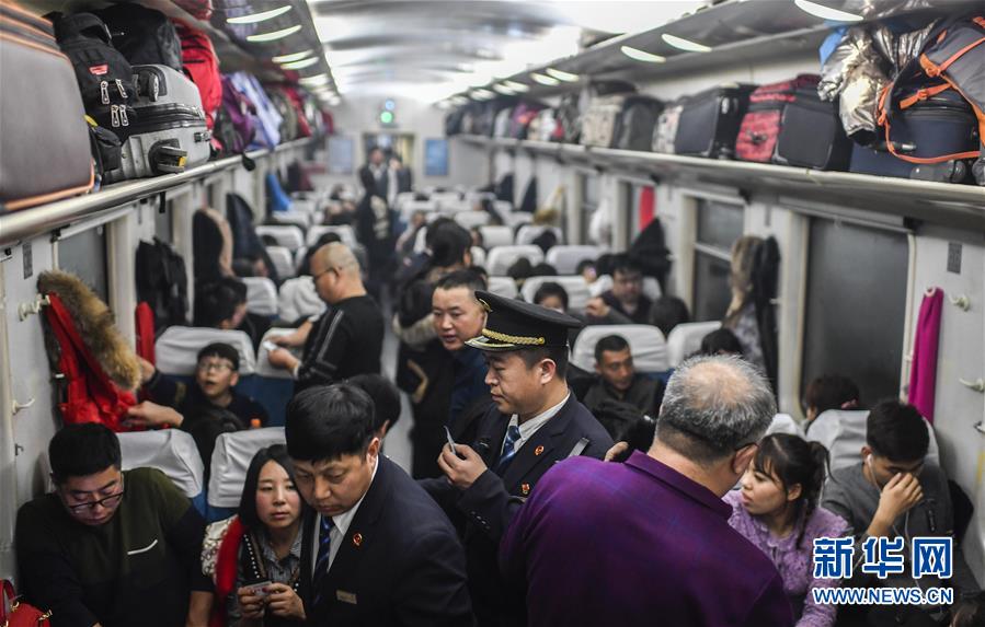 1月29日,李长明在k1023次列车硬座车厢检查旅客车票.