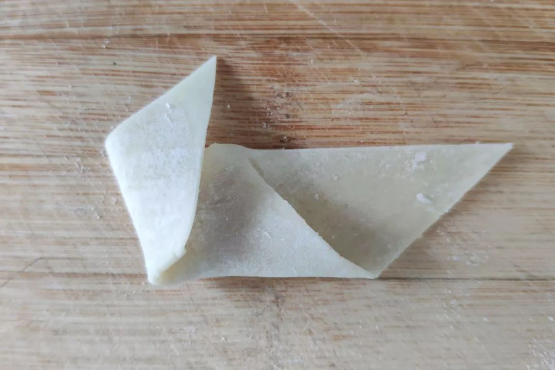 顺时针搅拌成肉馅; ■ 先将馄饨皮切成两半,变成两个三角形,取其中的