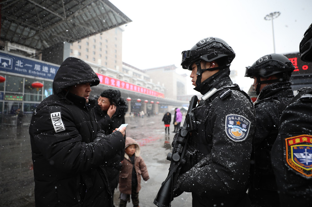 旅客春运返程 特警冒雪执勤