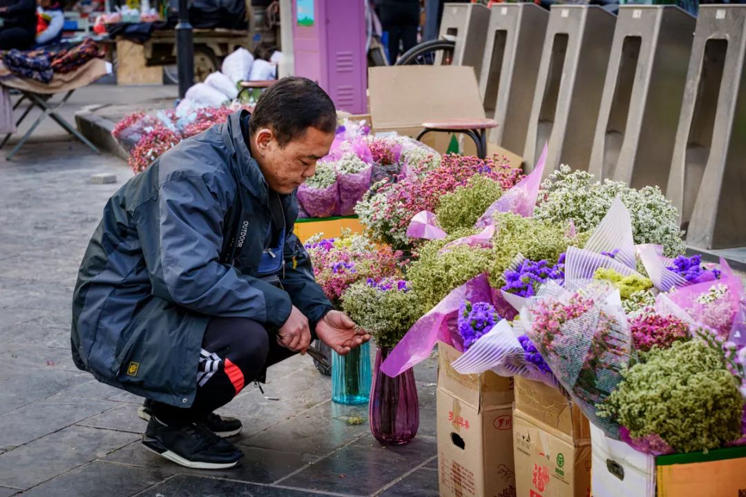 路边理发师坚守着老手艺,卖糖葫芦的人来回吆喝,商铺外的猫咪懒懒地趴