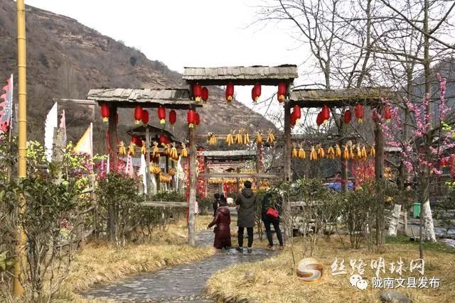 而在位于甘肃陇南文县白马藏寨,白马男女身着盛装,站在山寨门口迎接