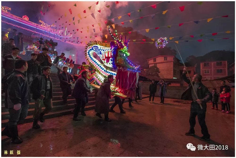 夜幕初降,魁城村的"龙头"在慈济宫敲起锣鼓,村民陆续扛出一节板凳龙灯