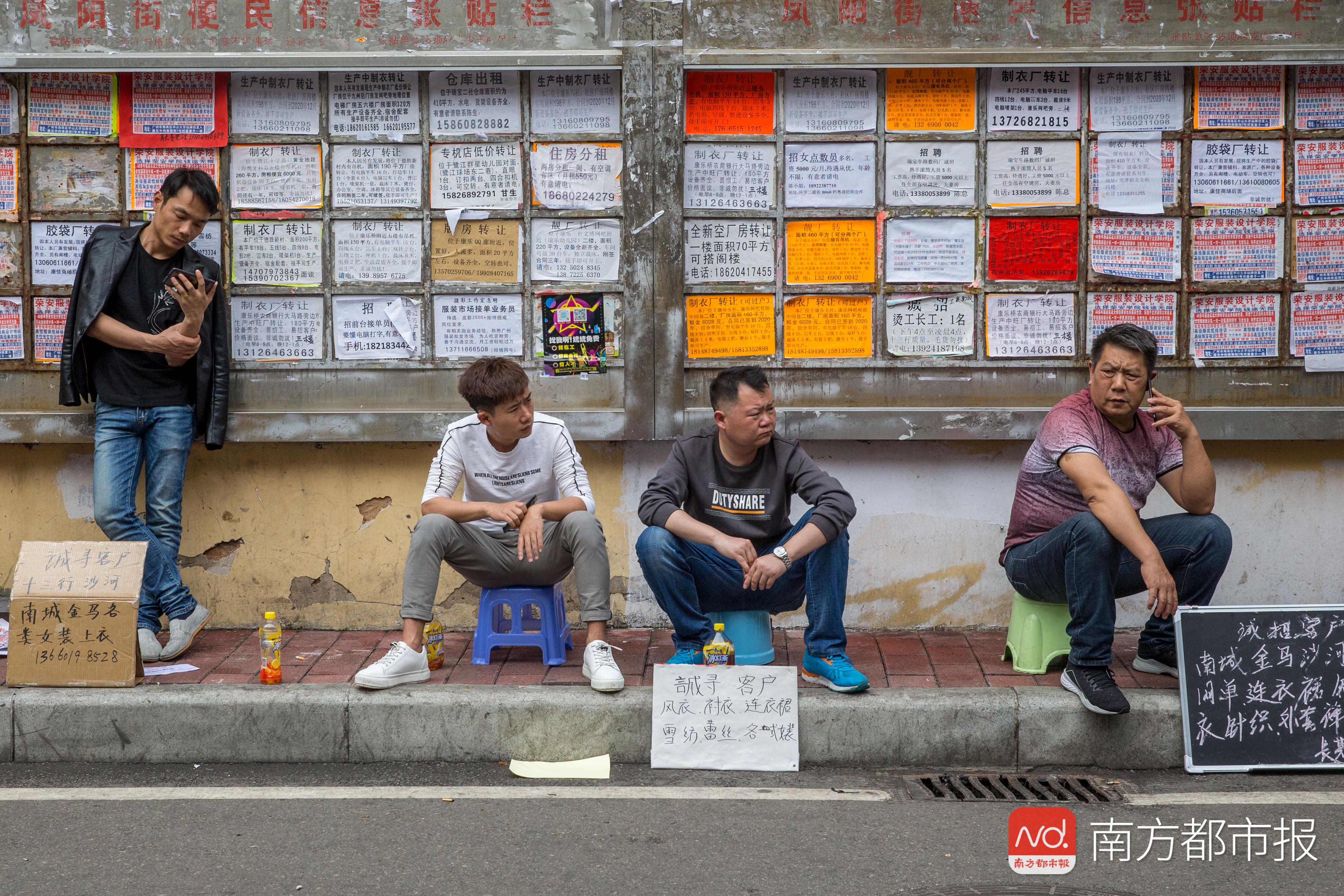 广州康乐村,制衣小作坊的"老板"们在路边等候,他们打出的不是"招工"的