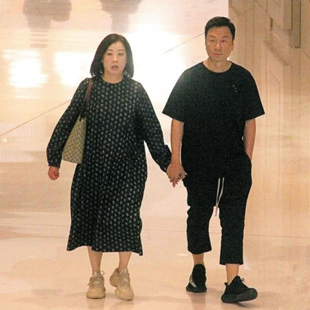 54岁黎耀祥近照,夫妻俩手牵手逛珠宝店,老婆胖了一圈