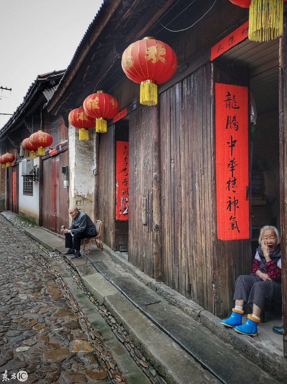 毛坦厂明清老街,坐在门口的老人,看着雨巷中的游人来来往往