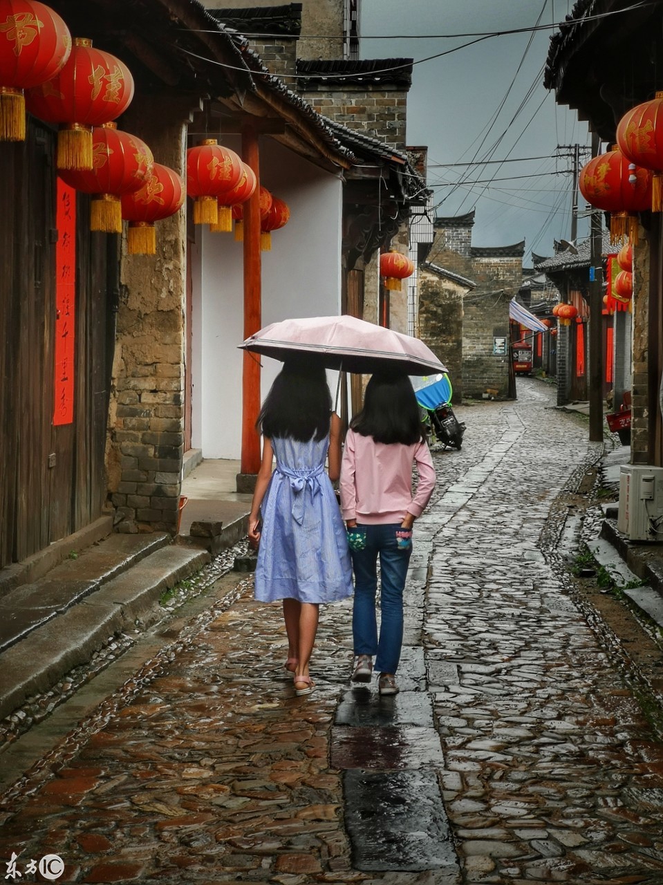 毛坦厂明清老街,坐在门口的老人,看着雨巷中的游人来来往往