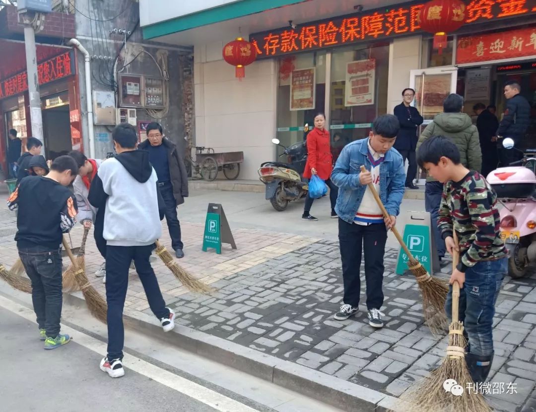 这里是超市门前,老师带着学生在打扫卫生.