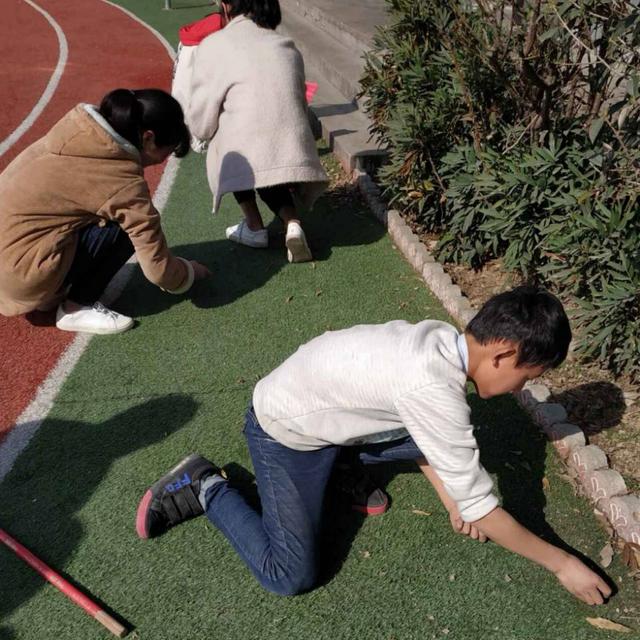 女生们也不顾脏土,认真的清理着,老师们索性脱掉外套,带头先干,孩子们