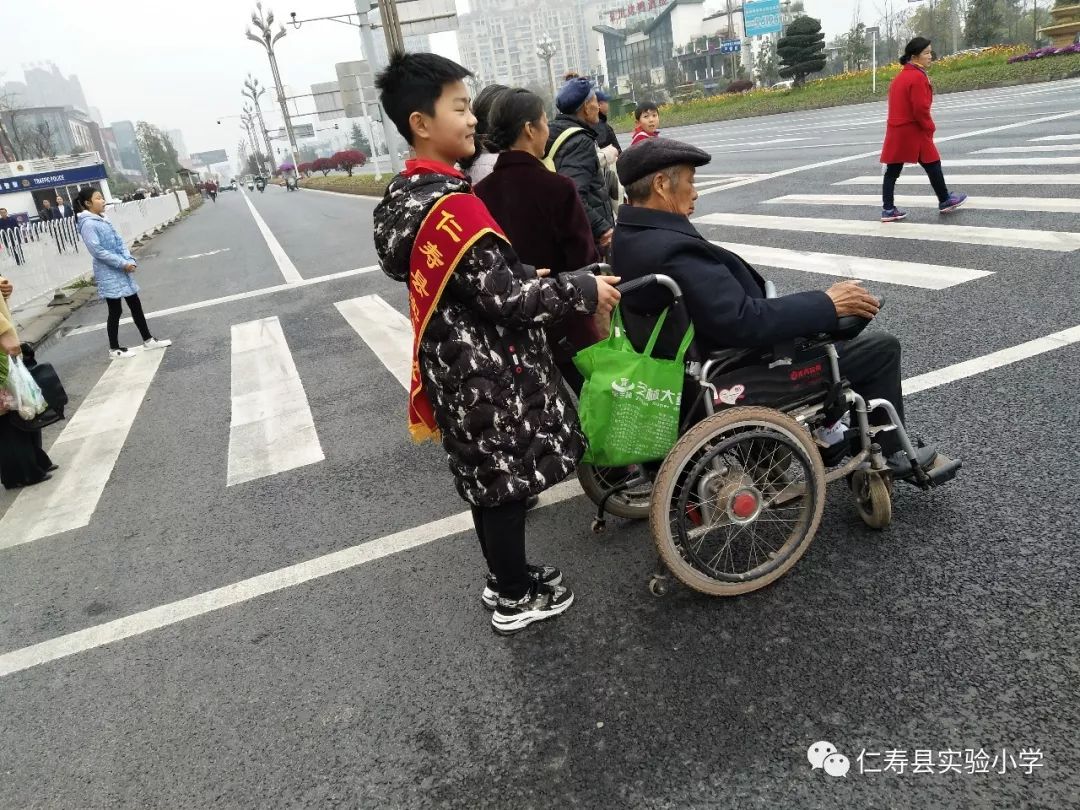 同学们热情帮助老人,残疾人过马路.