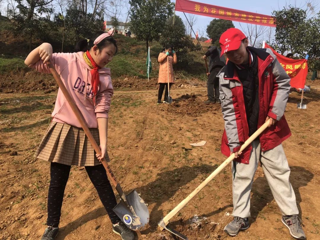 周末前去参加植树活动的705班唐子青同学和带领家人一起植树的石铮