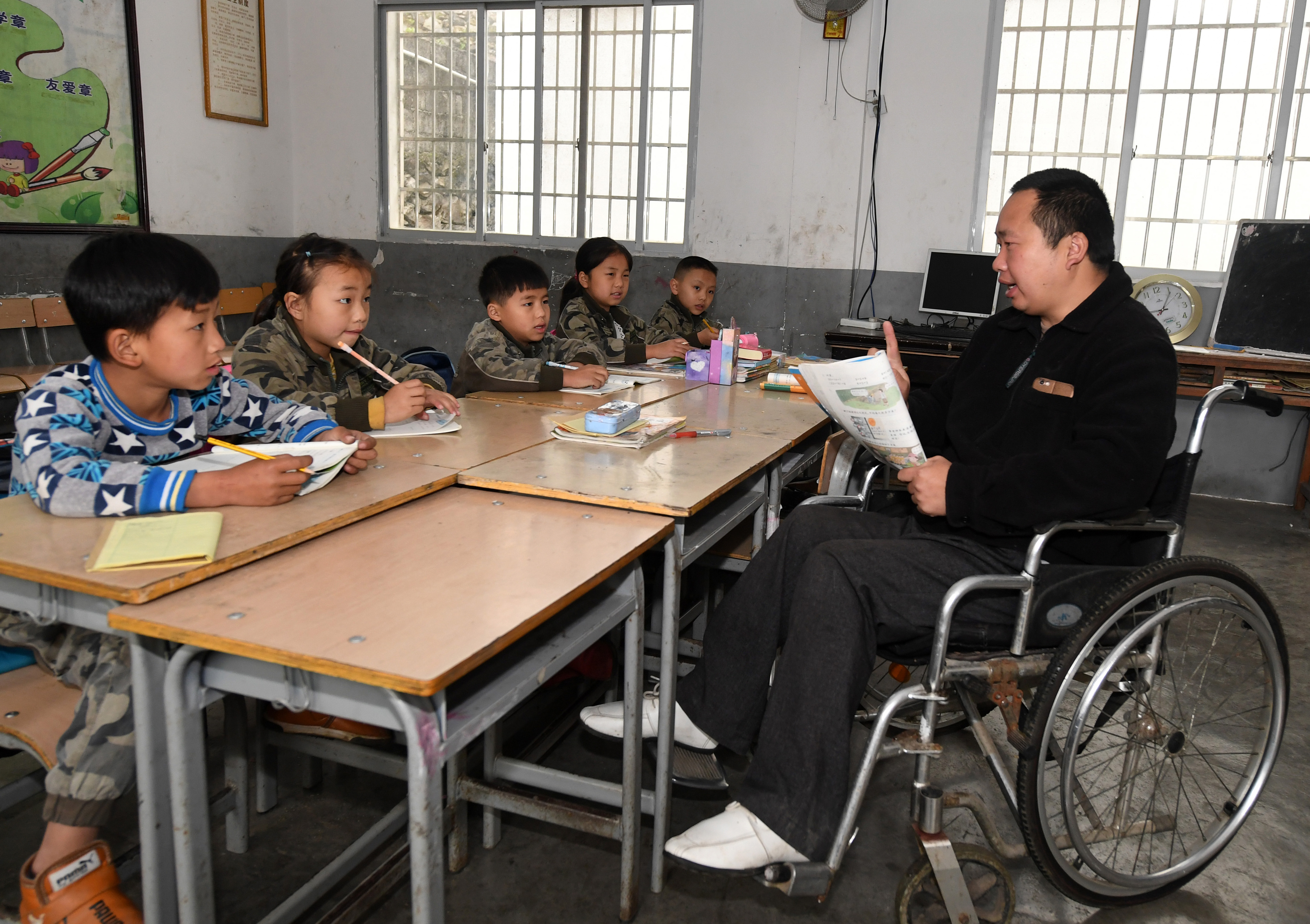 3月26日,在广西凌云县下甲镇河洲村念恩小学,阮文凭老师在给学生上课.