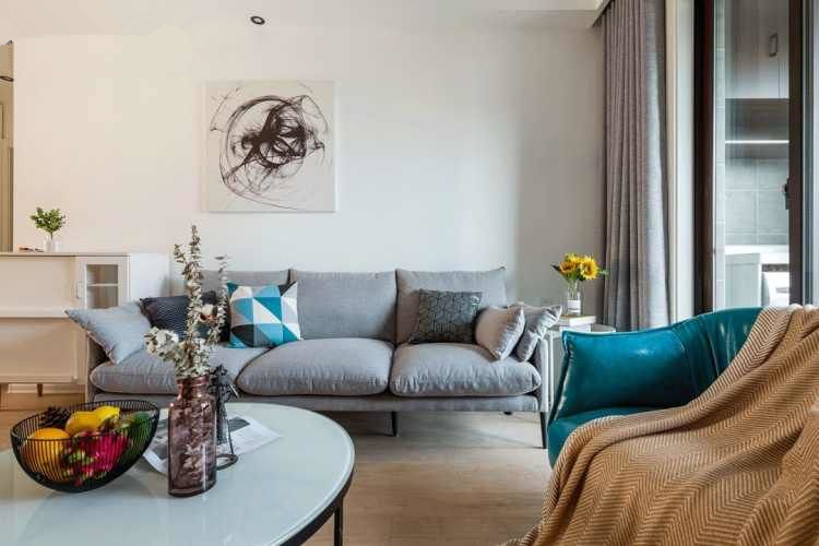 客厅的设计以灰白色为主,搭配布艺的沙发,并用蓝色作为跳色.