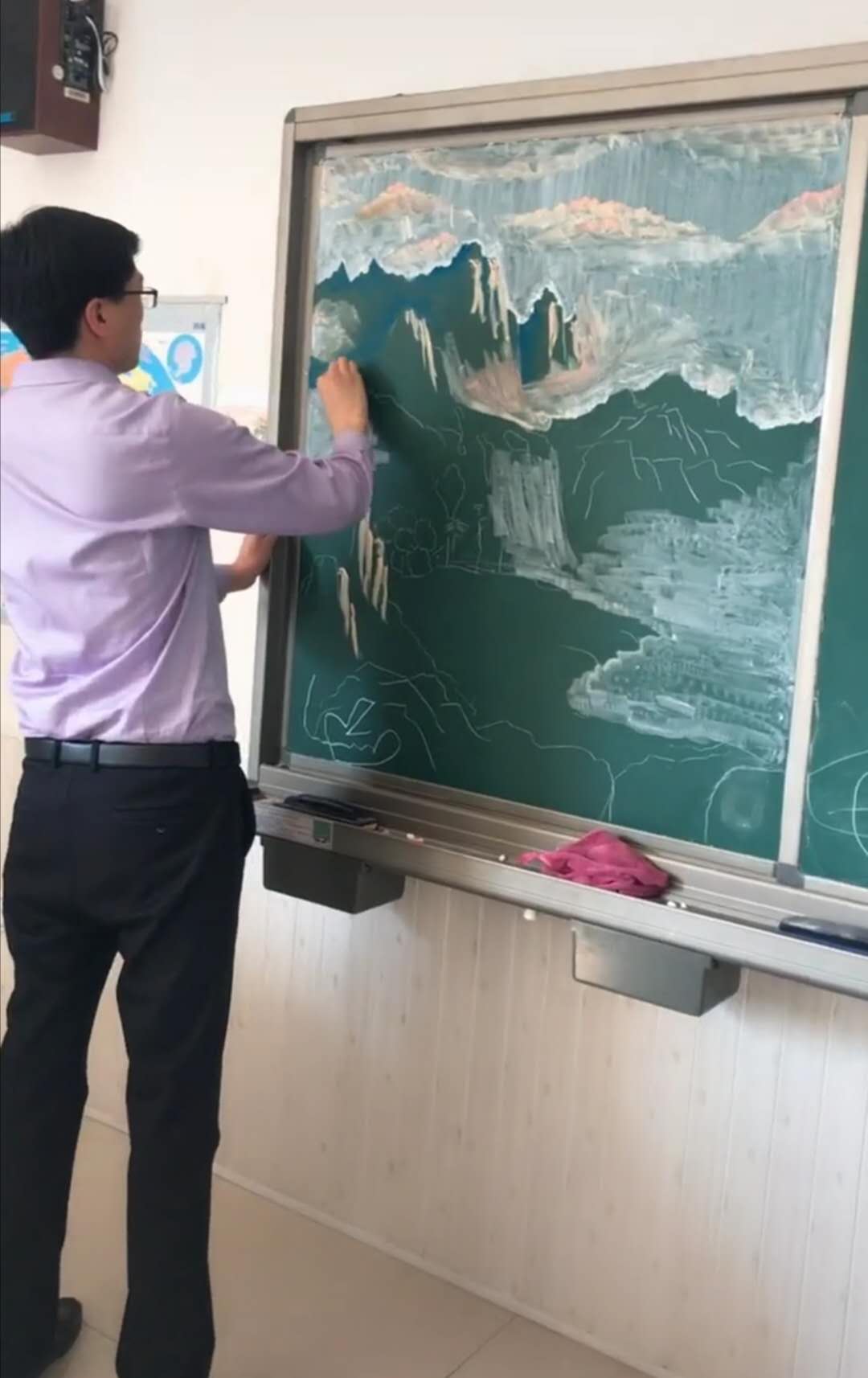 美术老师用粉笔画山水画,一手插兜很自在,看到成品不舍得擦黑板