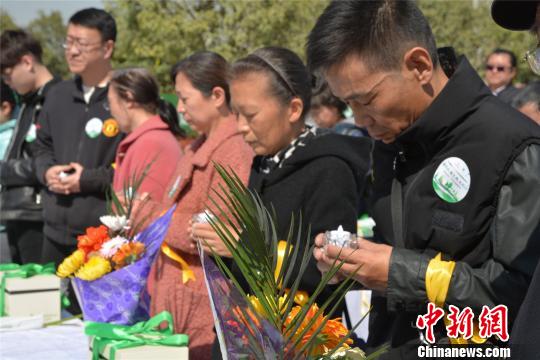 参加公益树葬的市民通过杯烛默哀送别亲人. 刘飞 摄