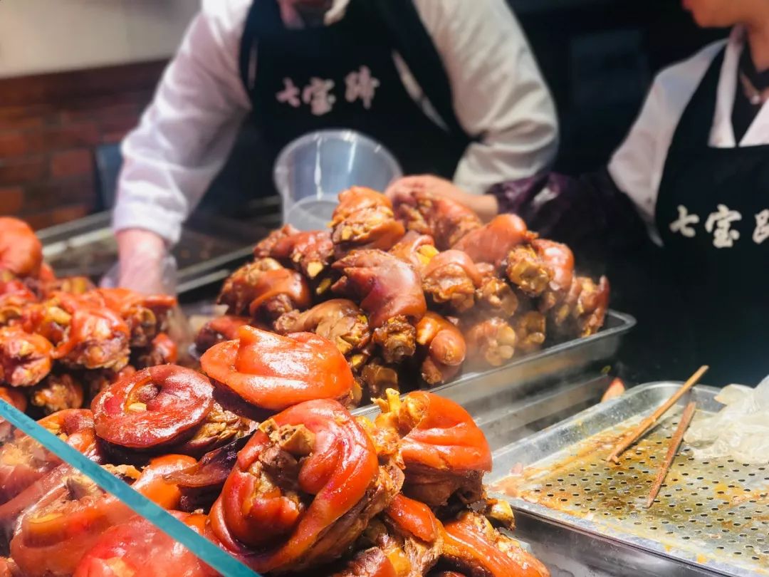 没走几步就见到了七宝老街地标美食——油光闪亮的大猪蹄子,台前围了