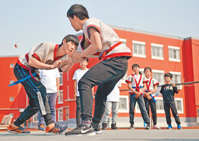 4月3日,安光小学学生在操场上练习摔跤.