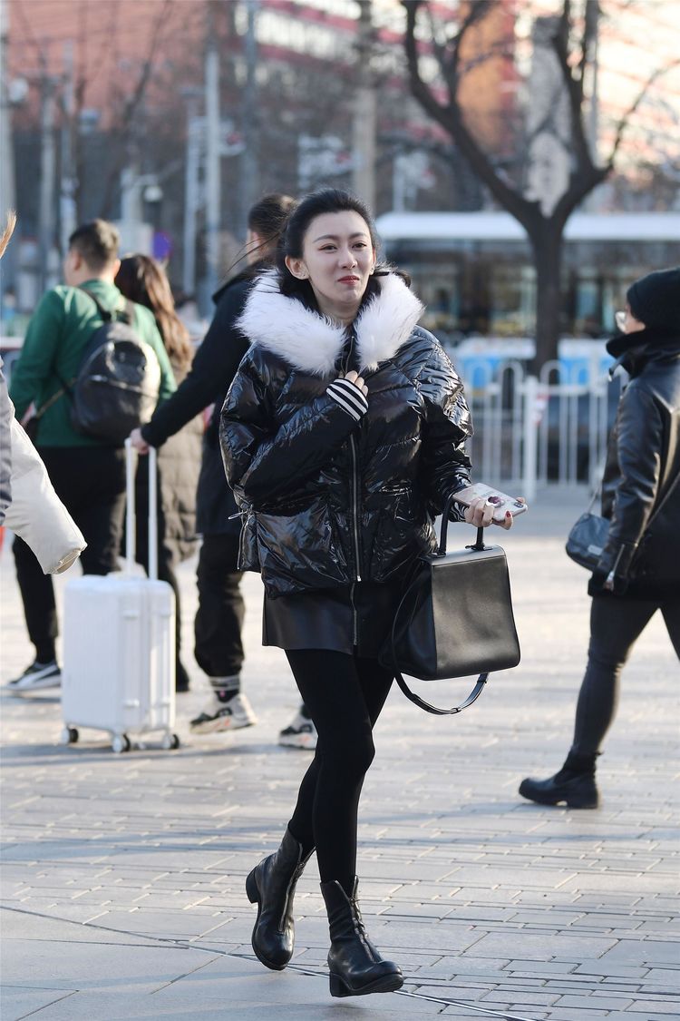 街拍:美女搭配粉红色的短款羽绒服,更显年轻,黑色连衣裙很时尚