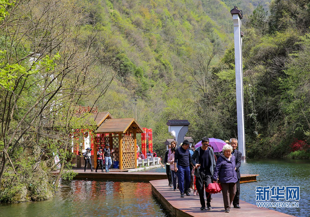 4月5日,平利县广佛镇桃花溪景点,游客在浮桥上喜笑颜开搀扶而过.