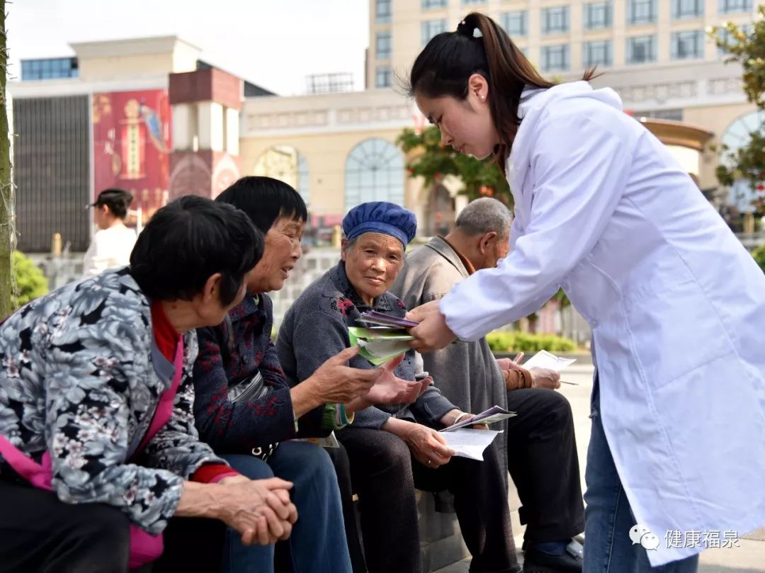 图为:医务人员宣传国家基本公共卫生服务项目