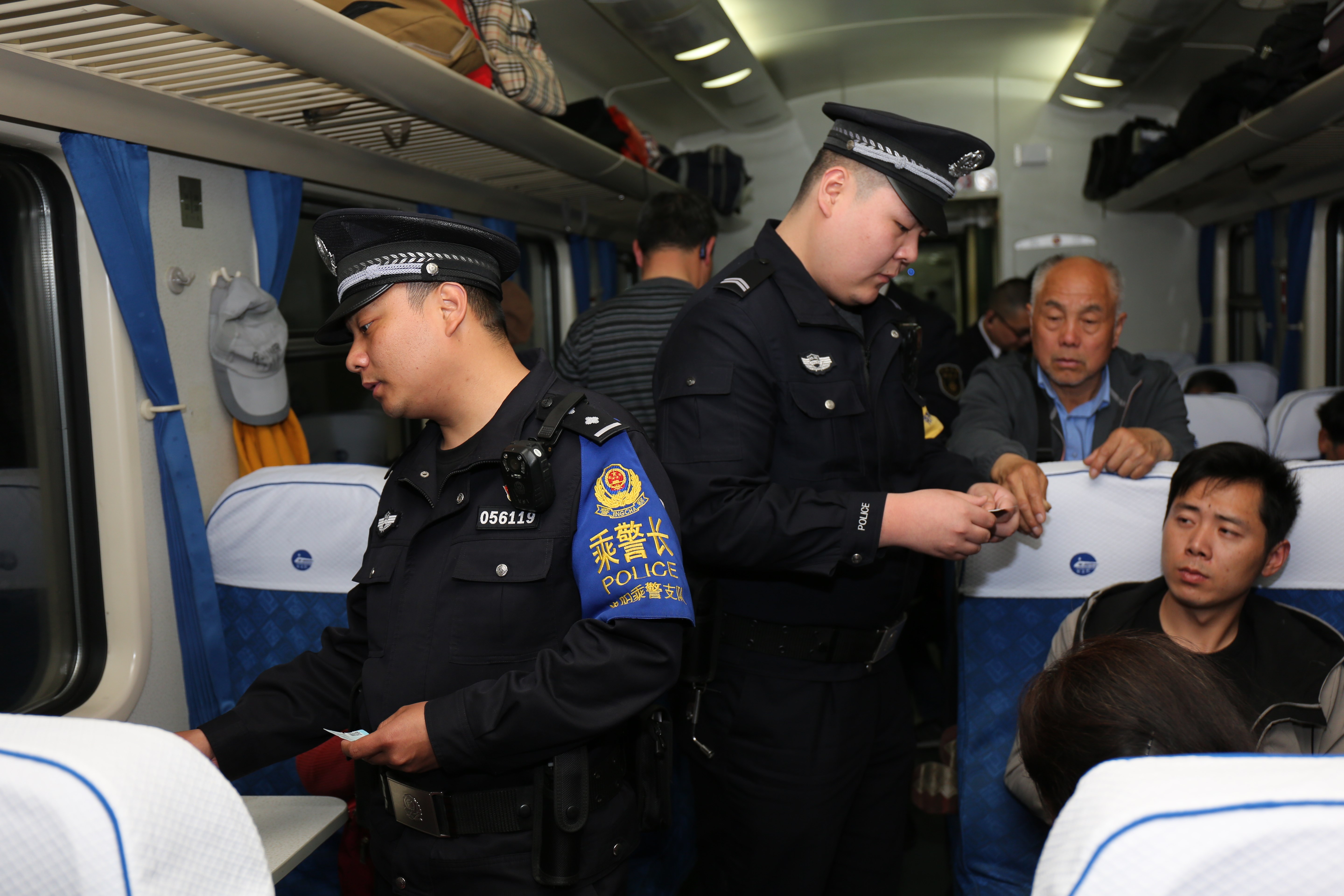 上图为乘警长薛江涛带领乘警杨俊华对车厢进行安检查危和夜间安全宣传