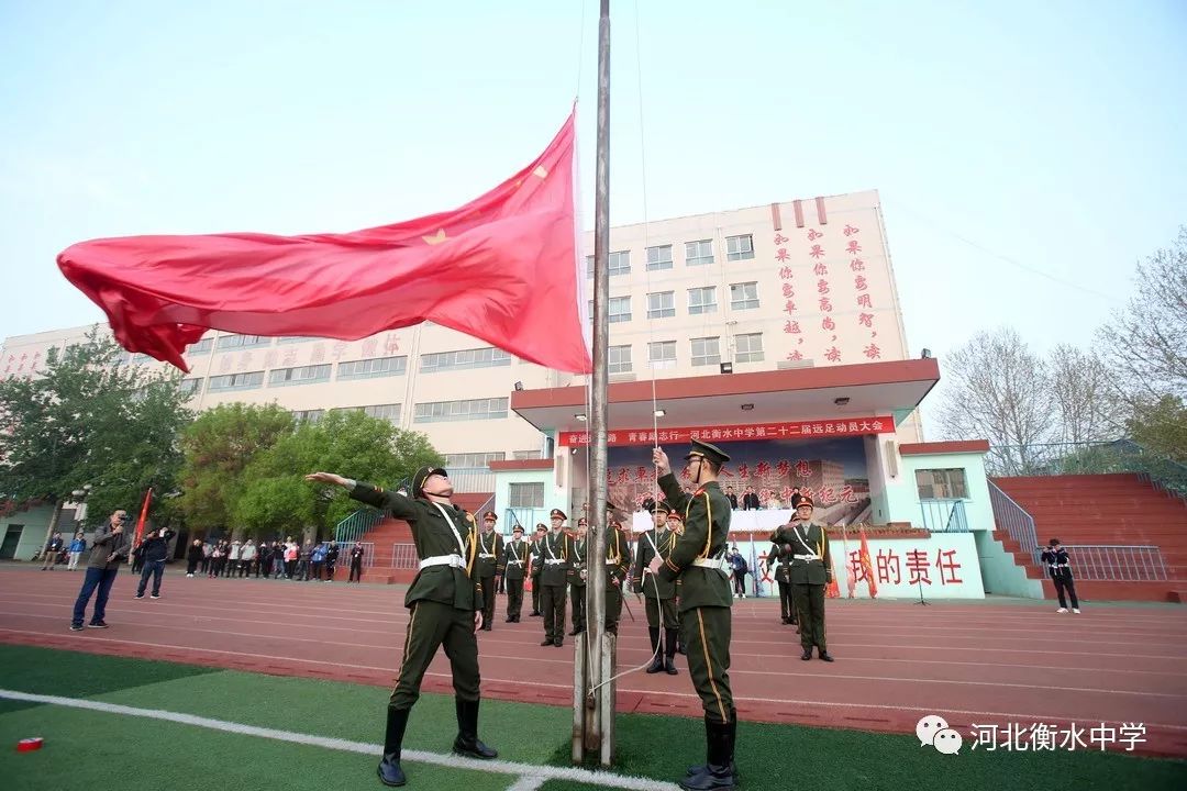 出征的孩子们迎着春风飘扬五彩的班旗天蓝的凉帽翠绿的草坪清晨的衡中