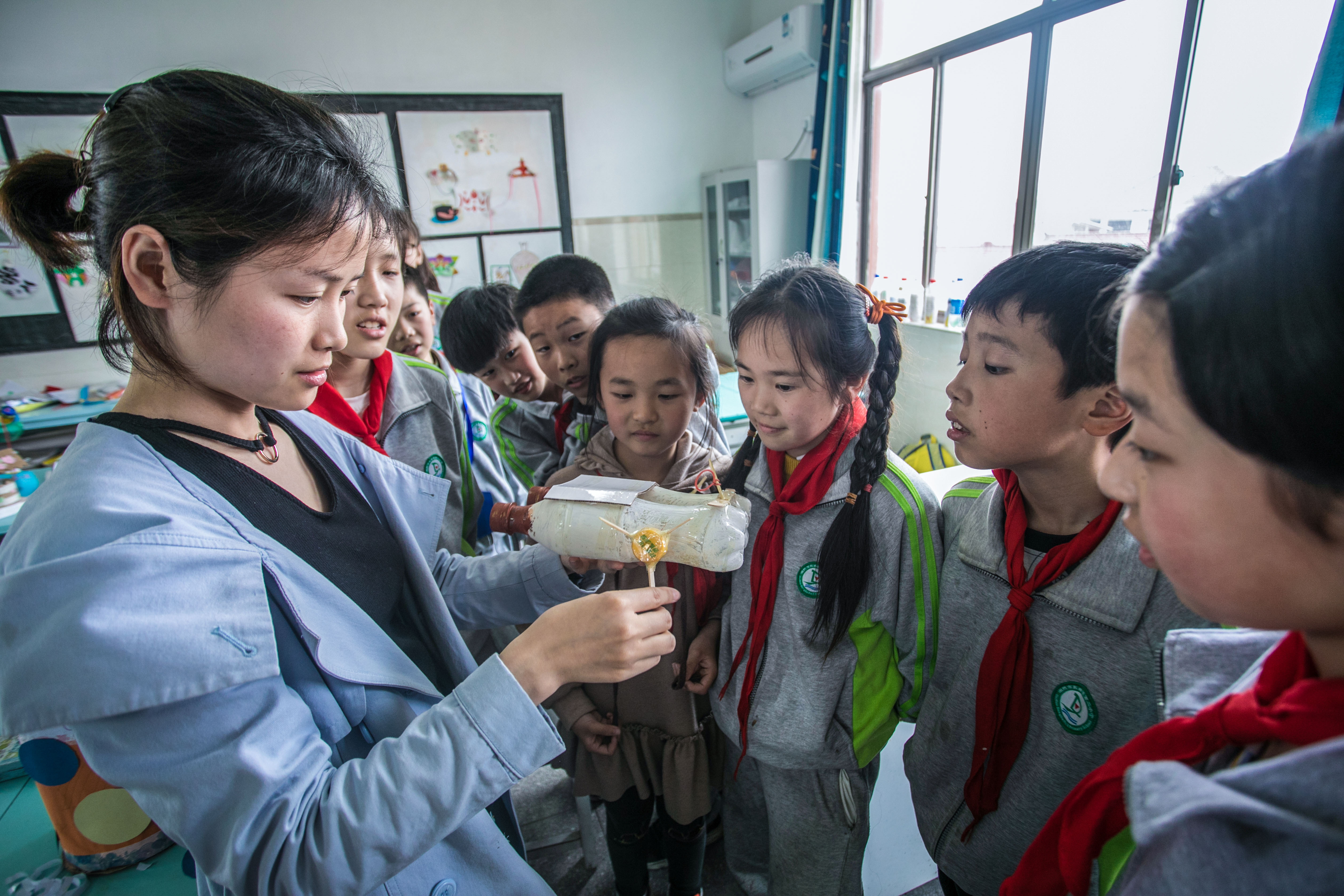 4月19日,湖州市东林镇第二小学老师在带领学生们用废旧瓶子制作小船